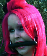 Sexy pink haired woman tied and gagged outdoors